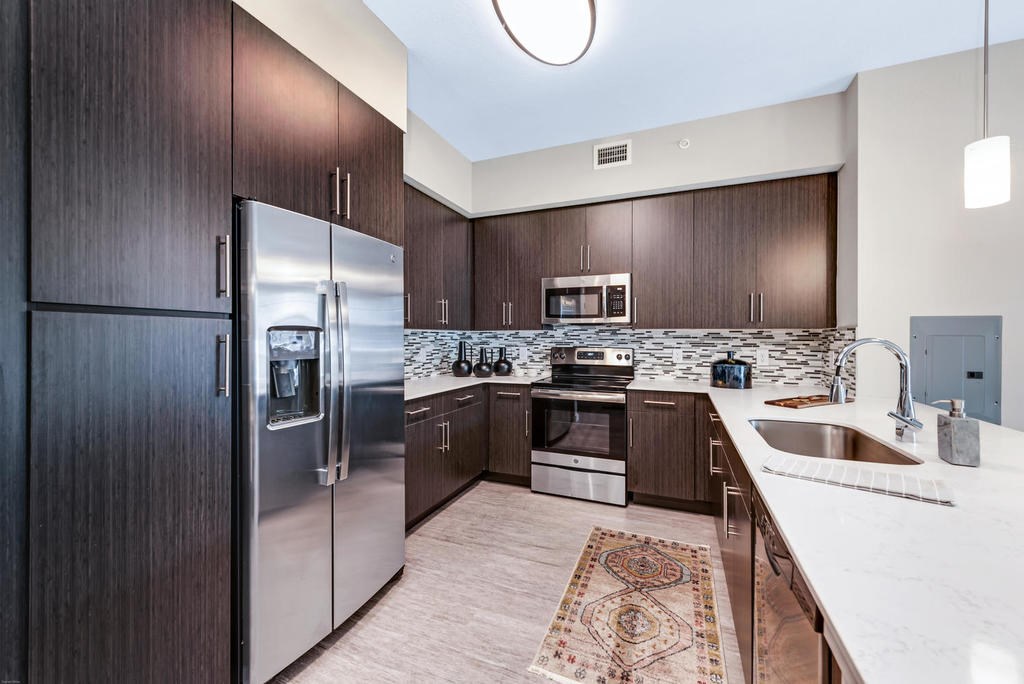 Kitchens with quartz countertops, stainless steel appliances, undermount sinks and 42" wall cabinets