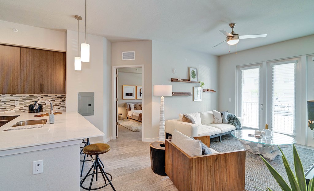 Large living area with hardwood-inspired flooring and ceiling fan