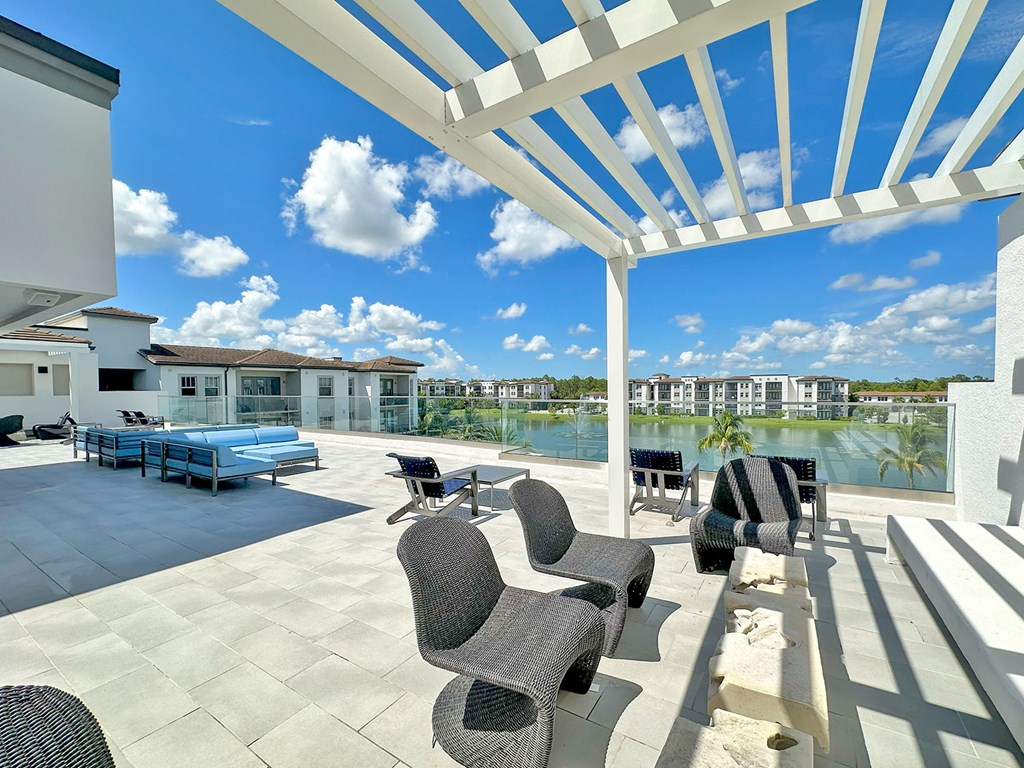 Partially shaded rooftop terrace with TVs, kitchen and bar