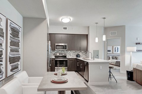 A modern kitchen with a dining table set for two.
