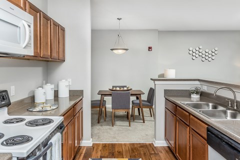 A kitchen with a dining table and chairs in the middle.