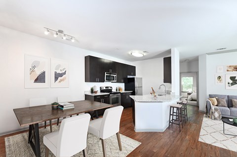 A modern kitchen with a dining table and chairs.