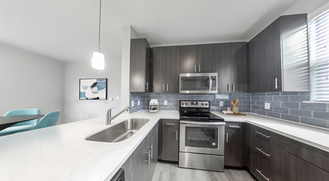 A modern kitchen with a stainless steel oven and a white countertop.
