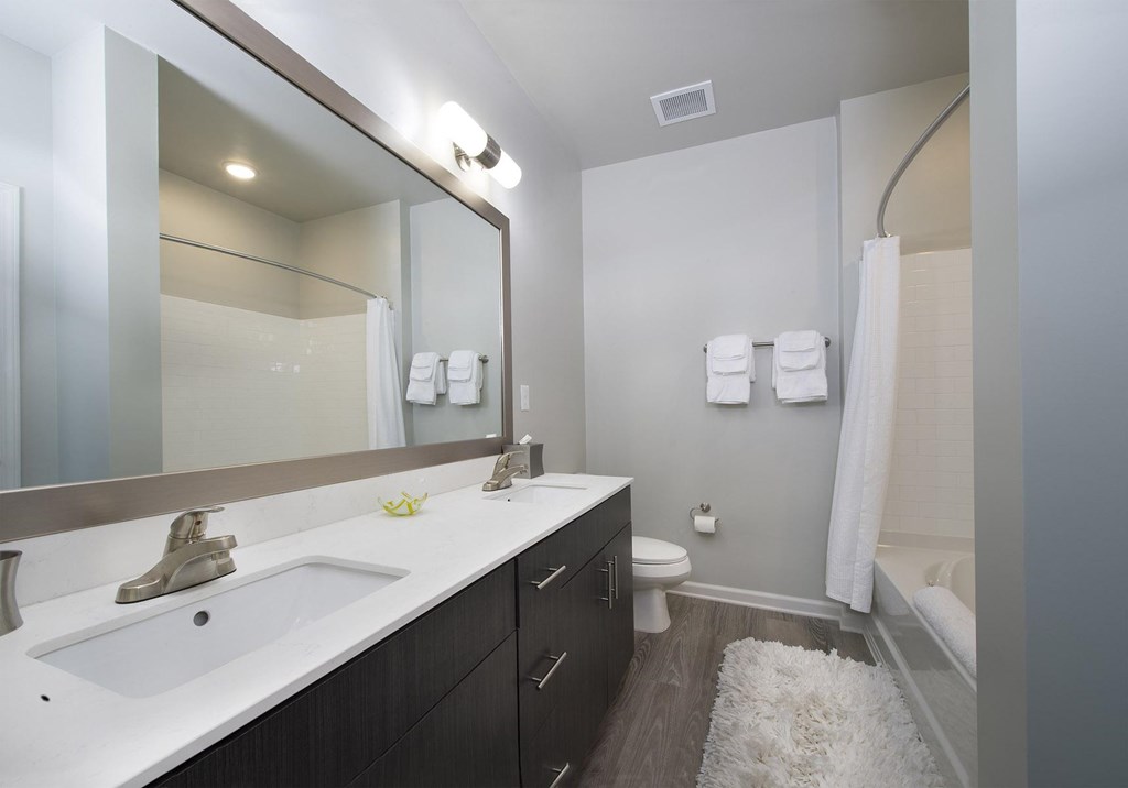 Bathrooms with quartz countertops, dual vanities and framed mirrors