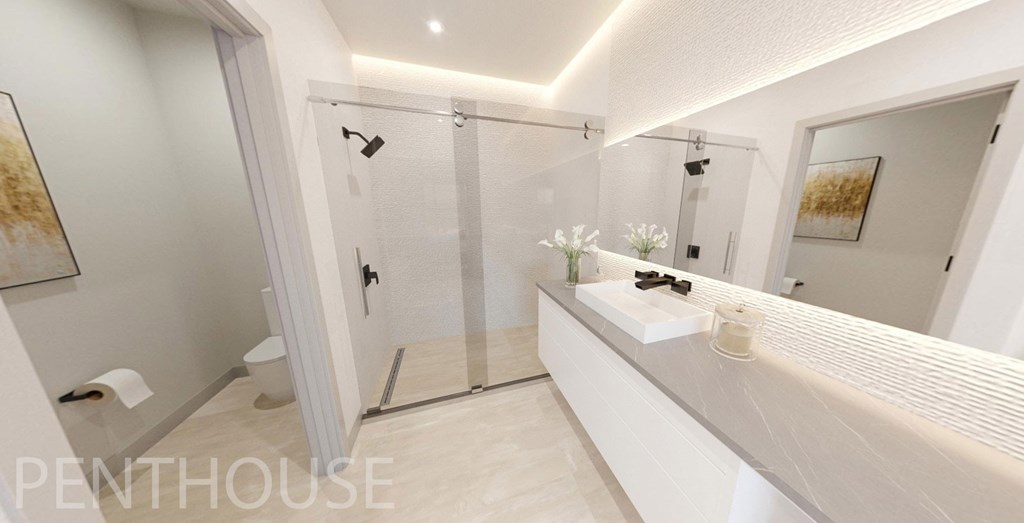 Frameless walk-in shower and quartz countertop in Penthouse bathroom
