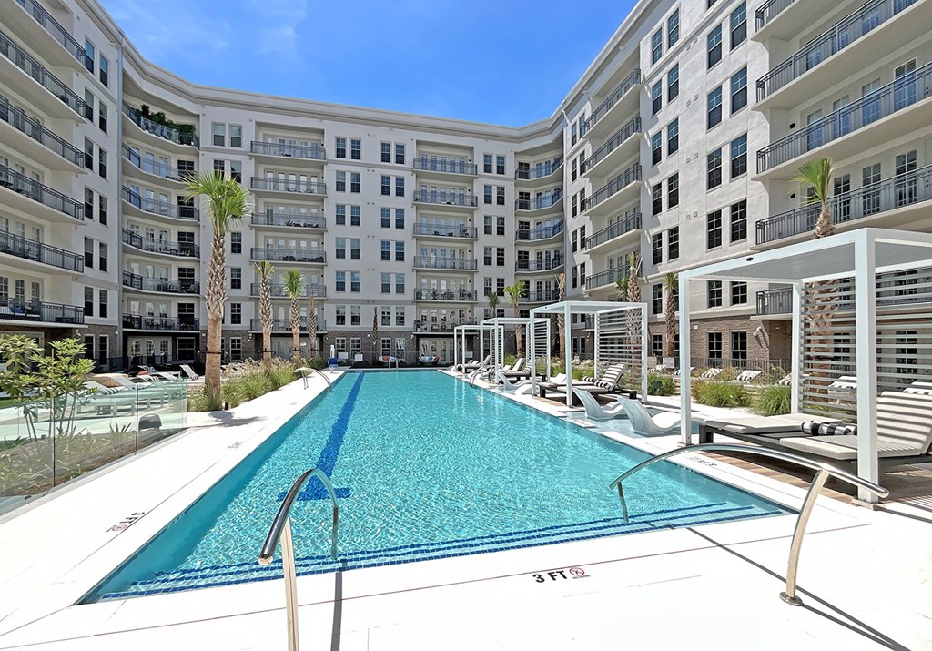 Infinity-edge saltwater pool with wet deck lounge, cabanas, lounge chairs and day beds