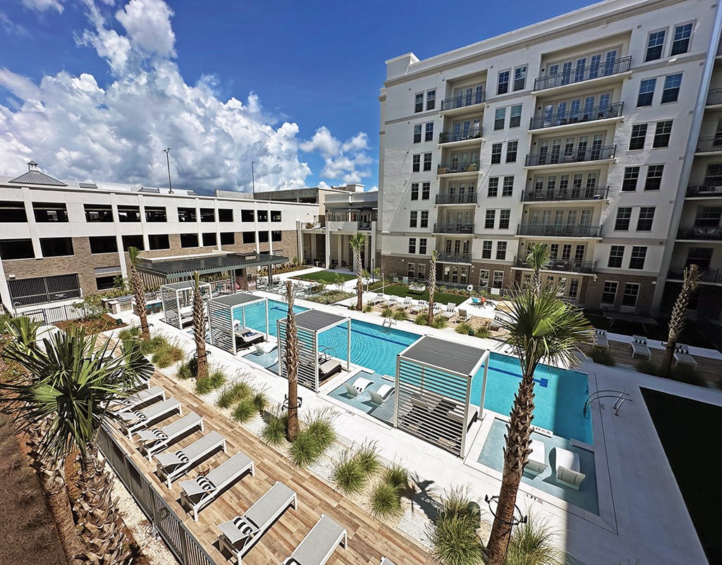 Infinity-edge saltwater pool with wet deck lounge, cabanas, lounge chairs and day beds