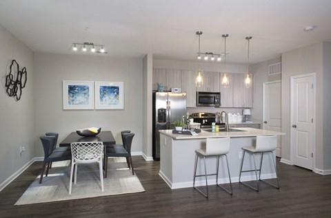 A kitchen with a dining table and chairs.