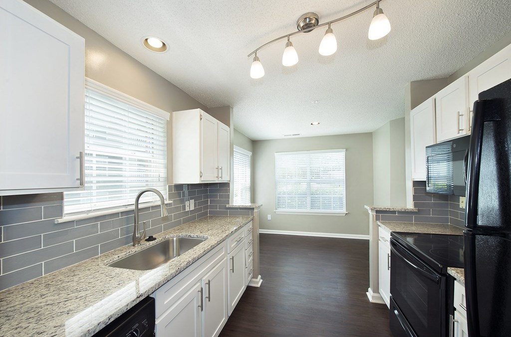 Suites with granite countertops and sleek black appliances (Signature)