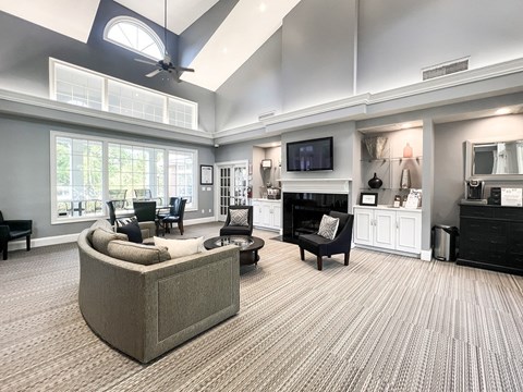 A living room with a grey couch and a television on the wall.