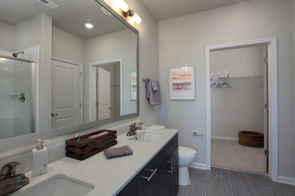 Bathrooms with quartz countertops, dual vanities and framed mirrors