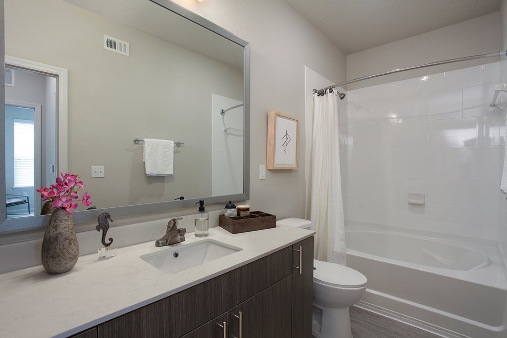 Bathrooms with quartz countertops and garden soaking tubs with curved shower rods