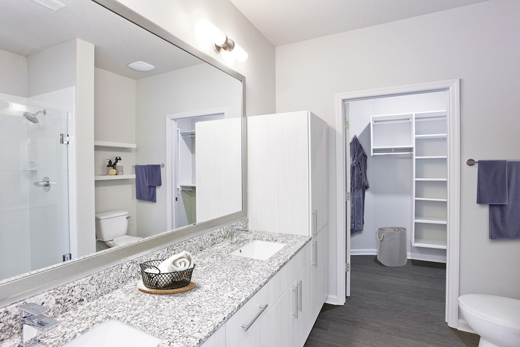 Granite countertops and framed mirrors in bathrooms