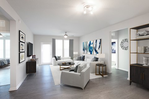 A modern living room with a white sofa set and a wooden floor.