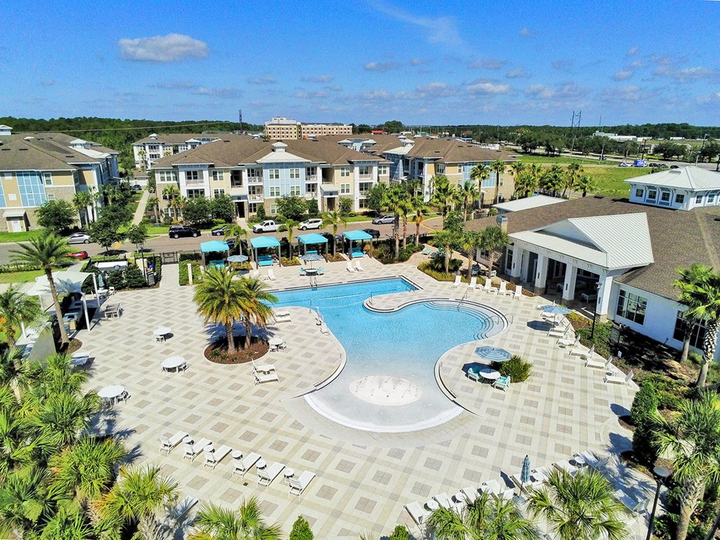 Beach-entry saltwater pool with splash pad, volleyball net, swim lane and cabanas