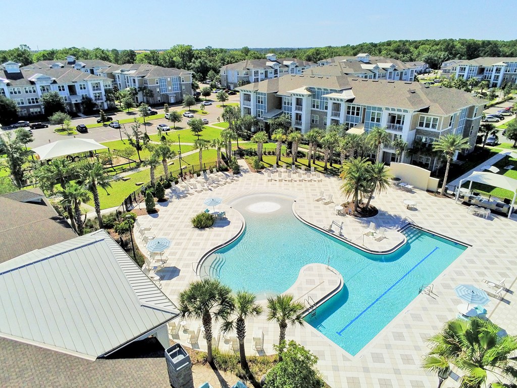 Beach-entry saltwater pool with splash pad, volleyball net, swim lane and cabanas
