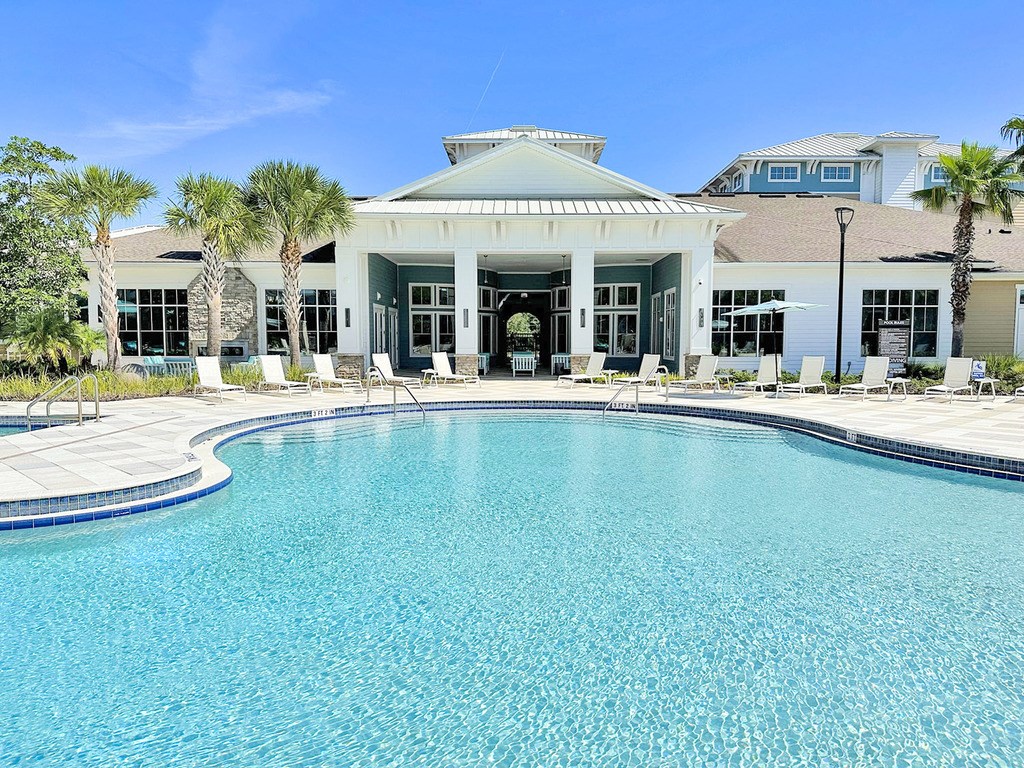 Beach-entry saltwater pool with splash pad, volleyball net, swim lane and cabanas