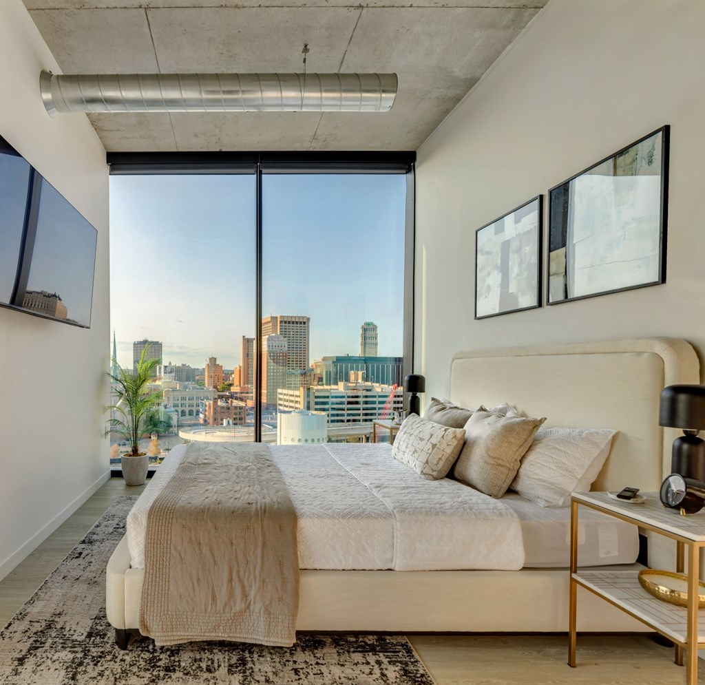 A bedroom with a large bed and a view of the city.