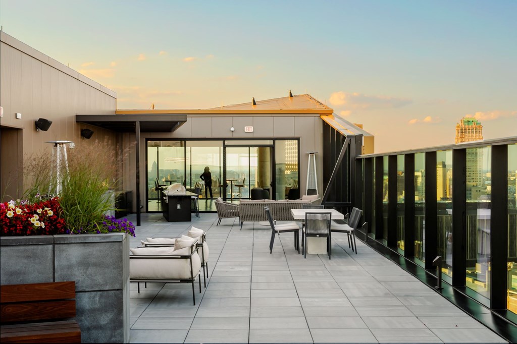 A modern patio with a table and chairs overlooking a cityscape.