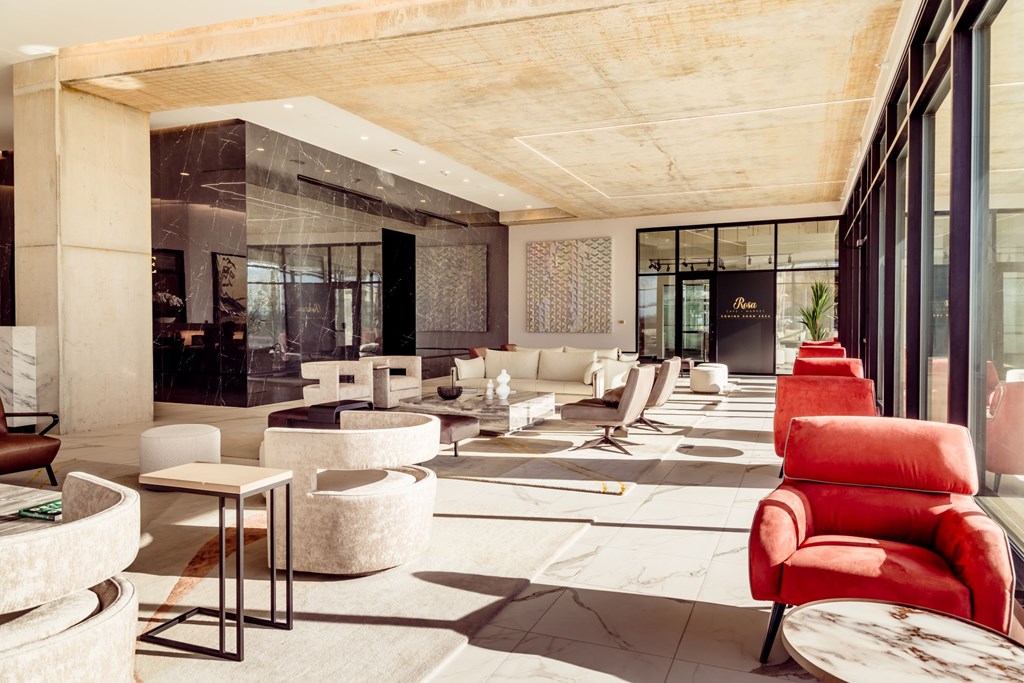 A modern living room with red chairs and a marble floor.