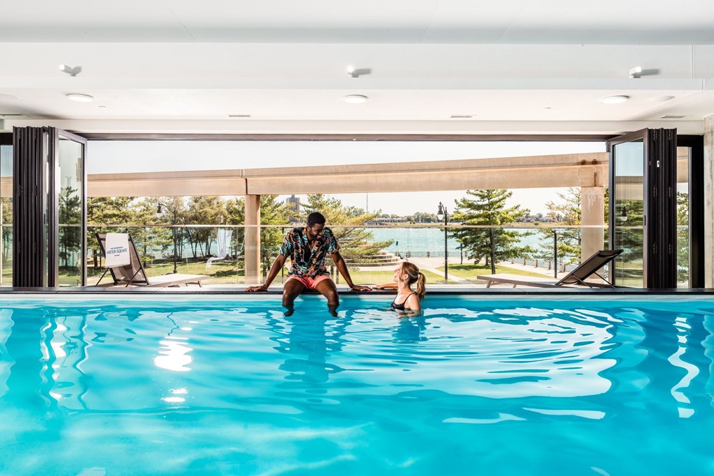 A man and a woman are in a swimming pool.