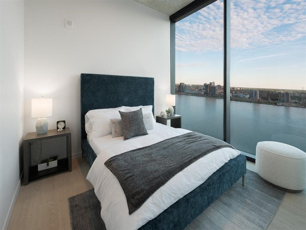 A bedroom with a large bed and a view of the city.