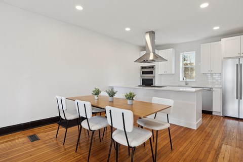 A kitchen with a table and chairs in front of it.