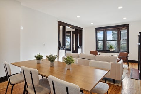 A dining room with a wooden table and chairs.