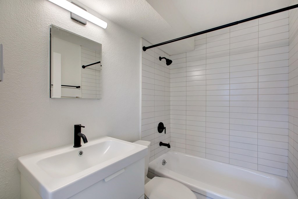 A white bathroom with a sink, toilet, and bathtub.