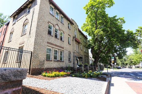 A building with a black fence and a gravel area in front.