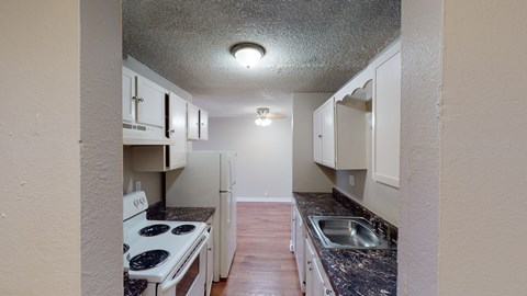 A kitchen with a stove top oven and a sink.