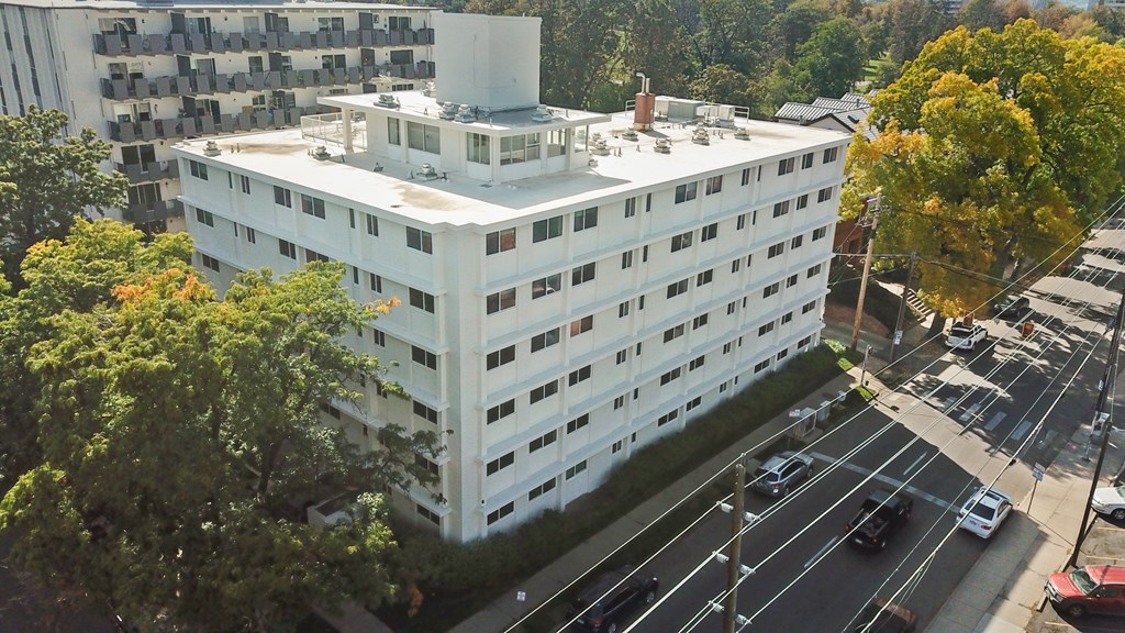 A white building with a parking lot in front of it.