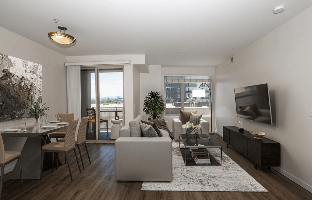 A modern living room with a grey sofa, a coffee table, and a television.