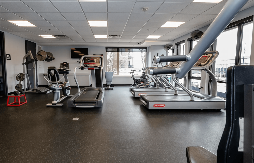 A gym with treadmills, elliptical machines, and other exercise equipment.