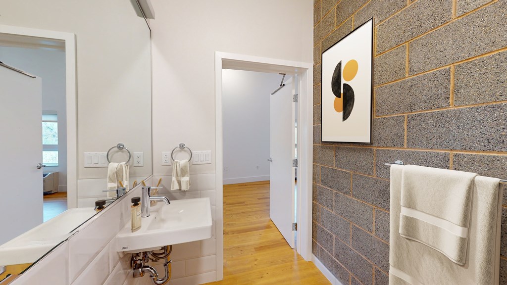 A bathroom with a white sink and a white towel hanging on the wall.