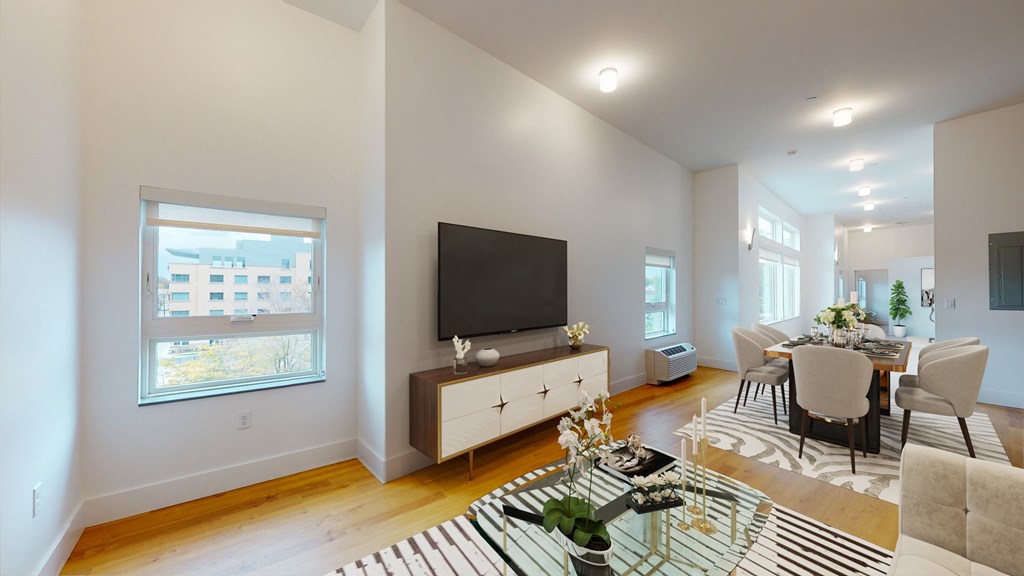A modern living room with a glass coffee table and a television.