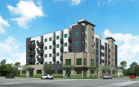 A modern apartment building with cars parked in front.