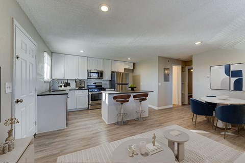 A modern kitchen with a dining area and a living room.