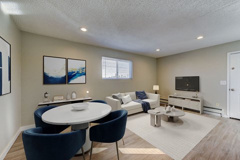 A modern living room with a white table and blue chairs.