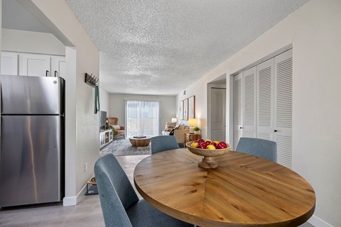 A modern kitchen with a wooden table and chairs.