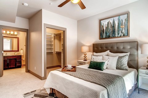 A bedroom with a large bed and a painting on the wall.