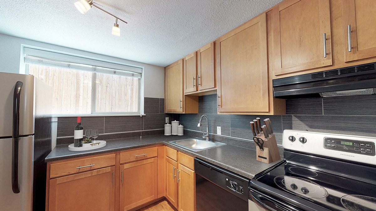 A kitchen with wooden cabinets and a black stove top oven.