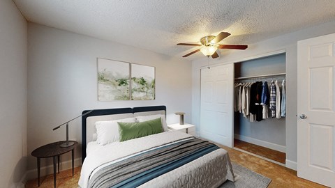 A bedroom with a bed, a ceiling fan, and a wardrobe.