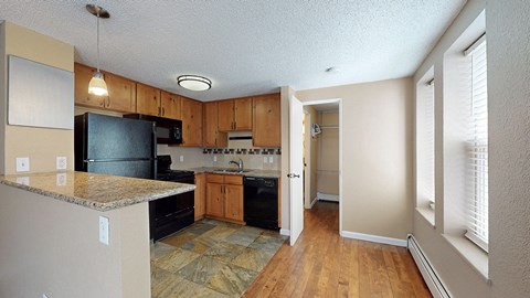 A kitchen with black appliances and wooden cabinets.