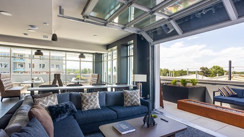 A modern living room with a dark blue sofa and a glass ceiling.