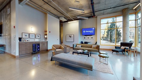 A spacious waiting room with a large couch and a flat screen TV mounted on the wall.