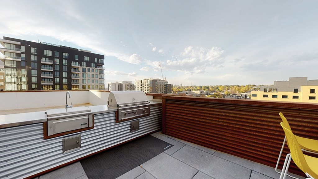 A yellow chair is on a patio with a view of the city.