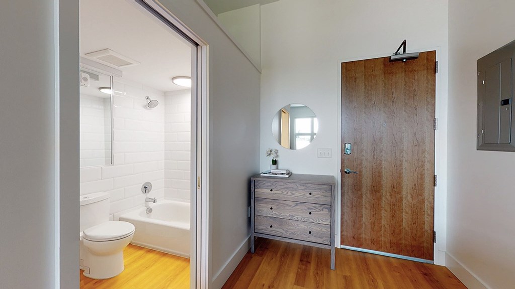 A bathroom with a toilet, a sink, and a wooden door.