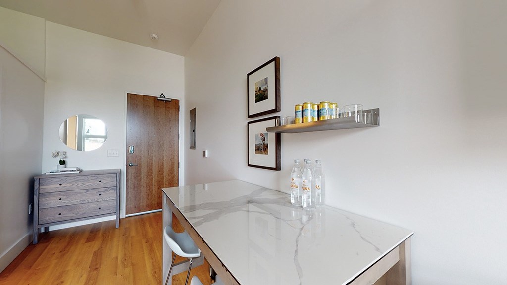A kitchen with a marble counter top and a framed picture on the wall.