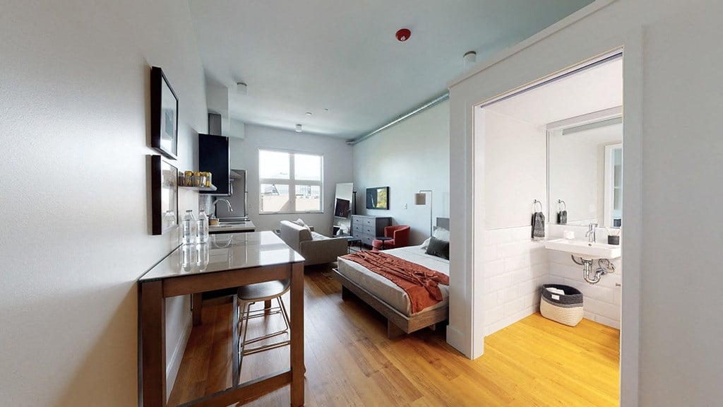 A modern bedroom with a bed, nightstand, and chair.